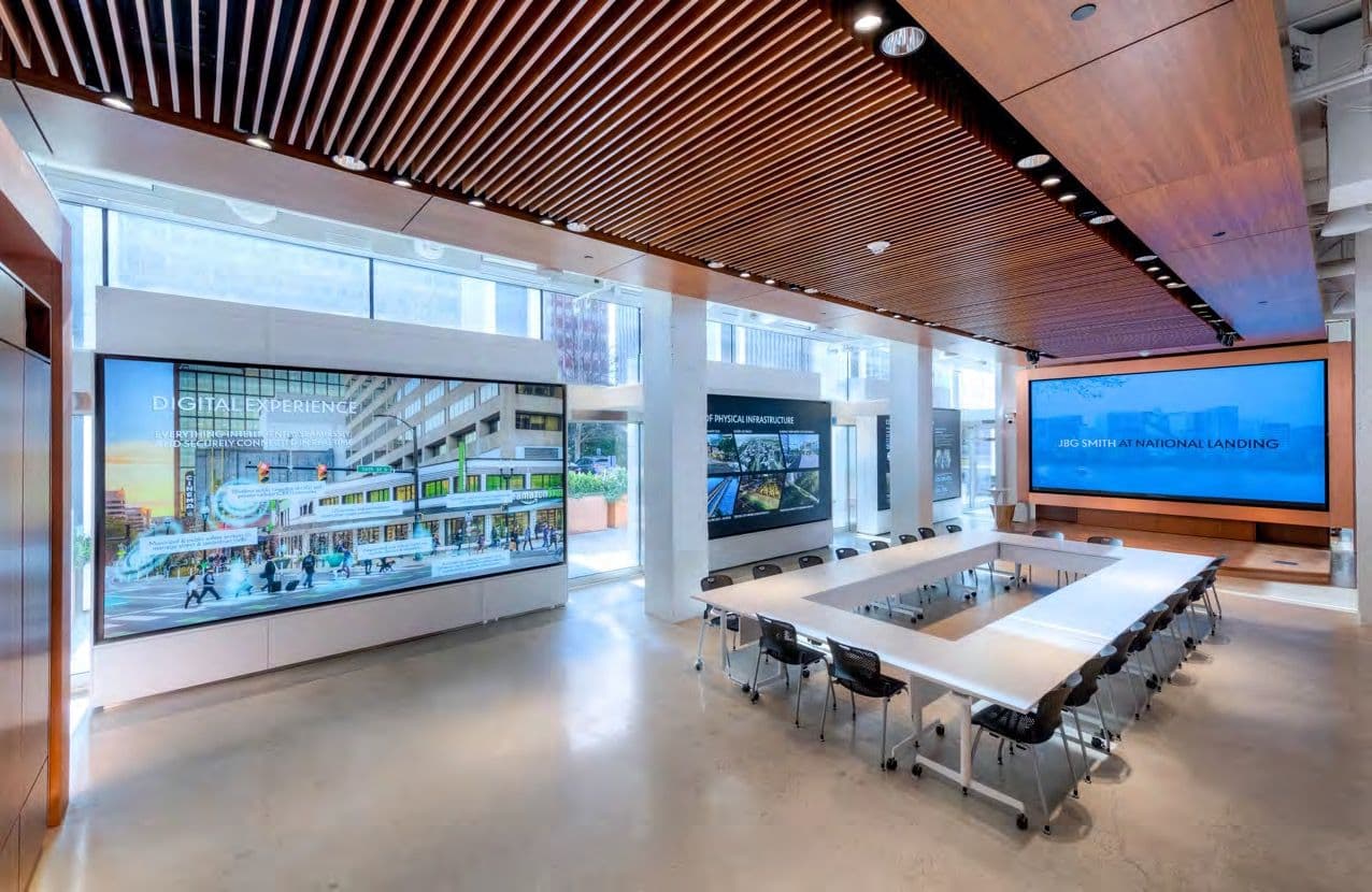 The Display Hall set up with an oval table facing a wall-size screen